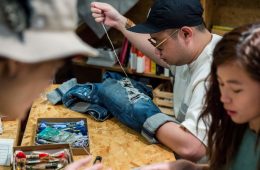 This picture taken on September 9, 2018 shows a participant at a "Fashion Clinic" workshop mending his old jeans. - Despite Hong Kong's reputation for rampant consumerism, a nascent movement against fast fashion is taking root in the city, with clothes-mending workshops and pop-up swaps growing in popularity, and designers parading recycled fabrics on the catwalk. (Photo by Isaac LAWRENCE / AFP) / TO GO WITH HongKong-fashion-environment-textile-lifestyle, FEATURE by Yan ZHAO (Photo credit should read ISAAC LAWRENCE/AFP/Getty Images)
